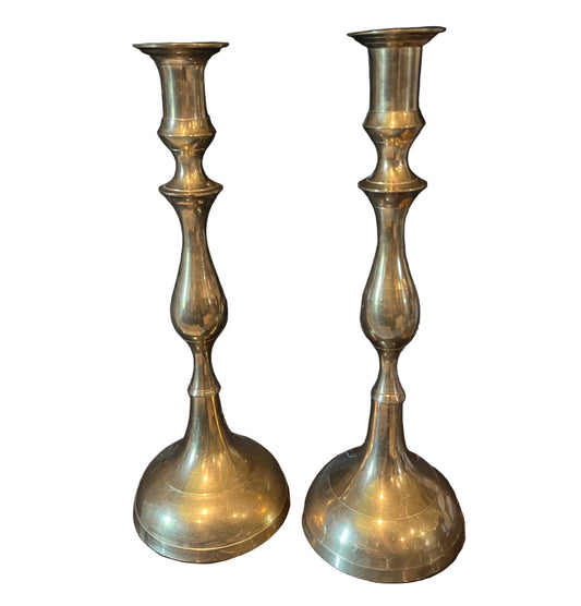 Two brass candle holders on a white background
