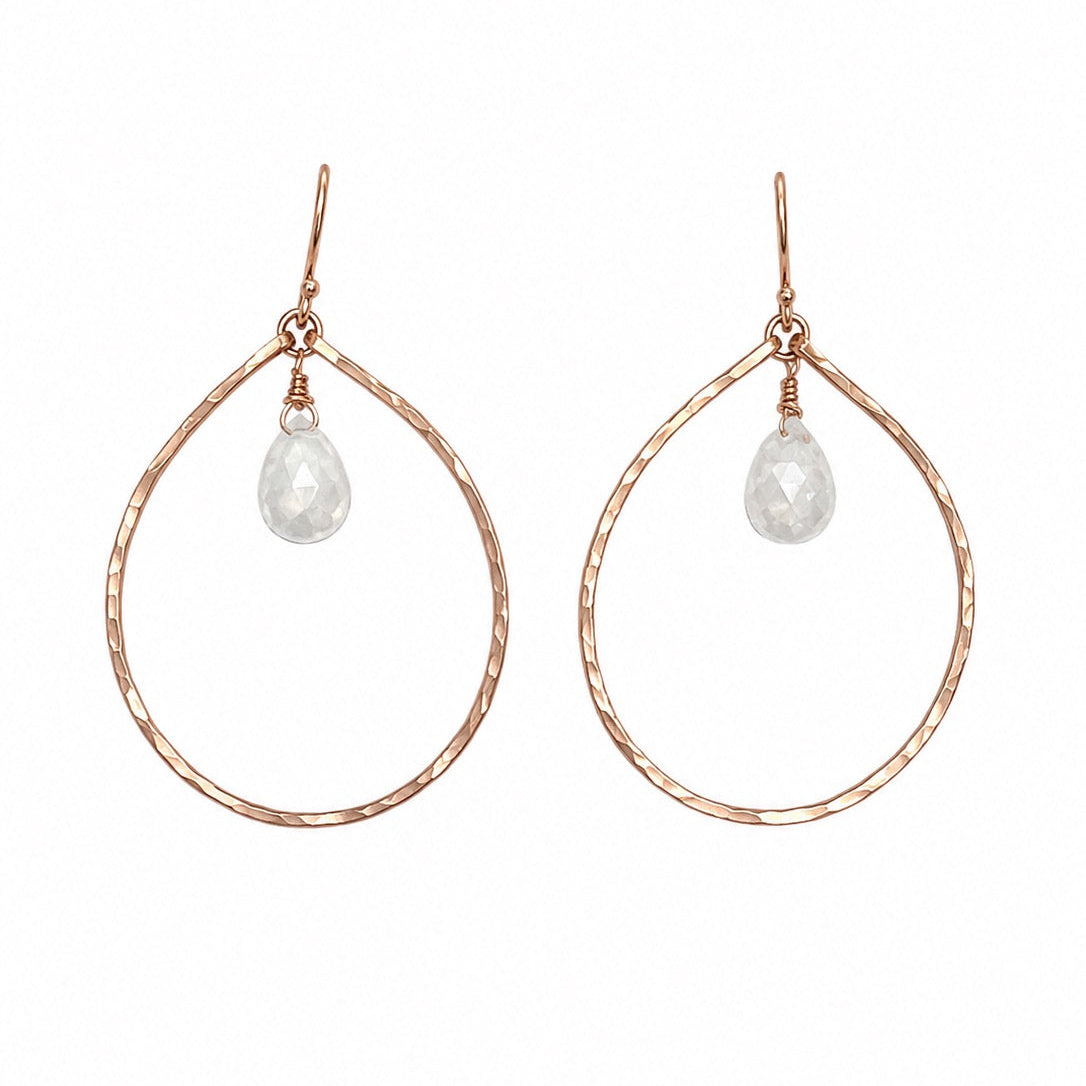 A pair of rose gold teardrop hoop earrings with a small faceted clear teardrop gemstone hanging from the top, shown against a plain white background.
