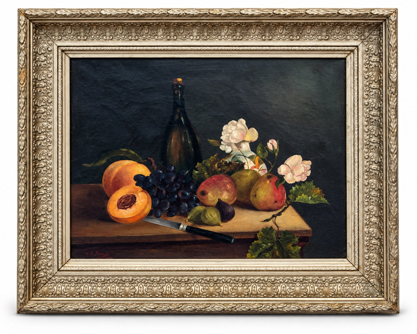 A framed still life oil painting depicting fruit, grapes, flowers, and a dark bottle on a table against a dark background, enclosed in an ornate gold-toned frame.