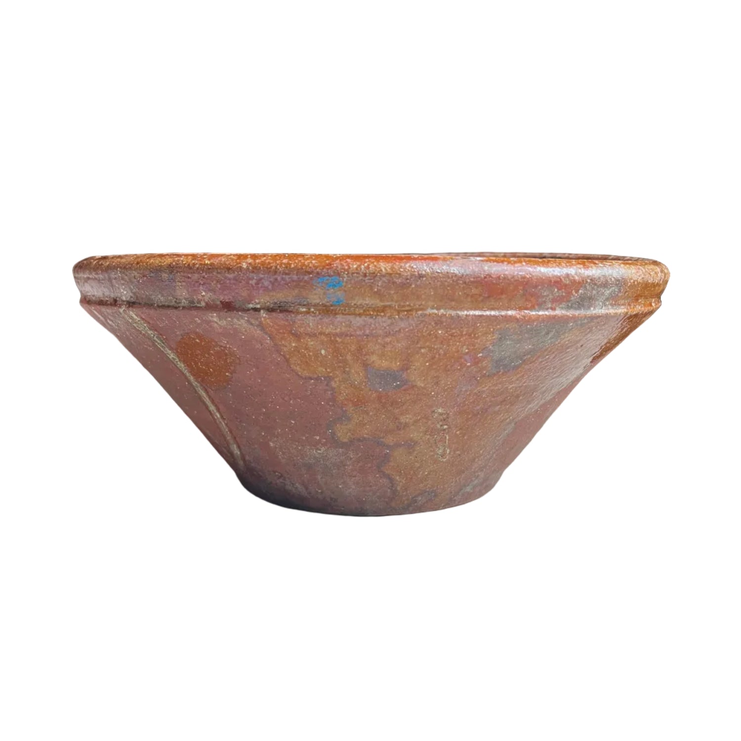 A rustic, hand-painted terracotta clay bowl with a wide rim, sitting on a light gray textured surface. The bowl features a mottled finish with earthy tones of terracotta, brown, and subtle hints of blue and gold.