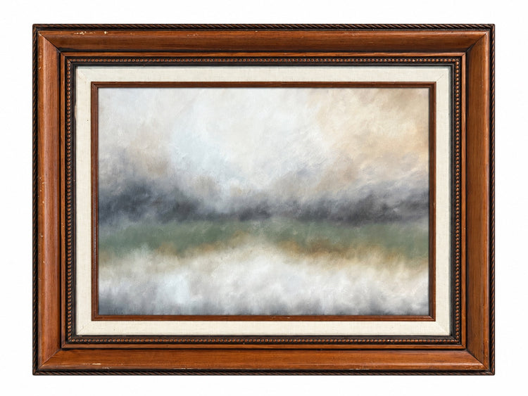 A framed landscape painting featuring a misty, atmospheric scene with soft gradients of gray, beige, green, and white, enclosed in a brown wooden frame with a cream mat.